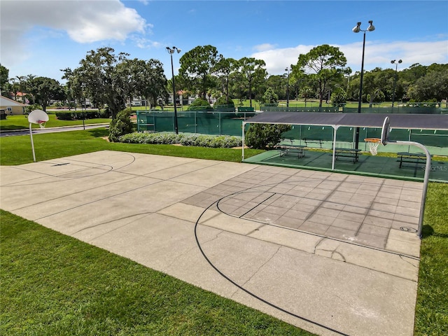 view of basketball court with a yard and a water view