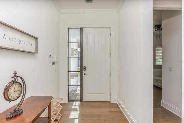 foyer with hardwood / wood-style floors and crown molding