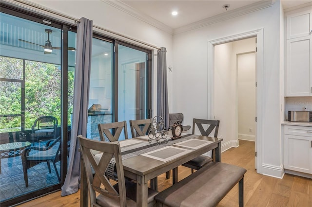 dining space featuring light wood-type flooring and ornamental molding