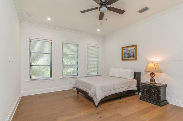 bedroom featuring hardwood / wood-style floors, ceiling fan, and ornamental molding