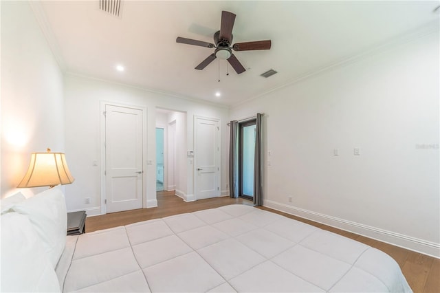 unfurnished bedroom featuring ceiling fan, light wood-type flooring, and crown molding