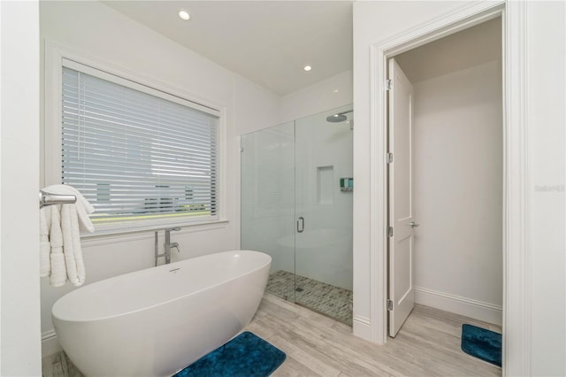 bathroom featuring wood-type flooring and plus walk in shower