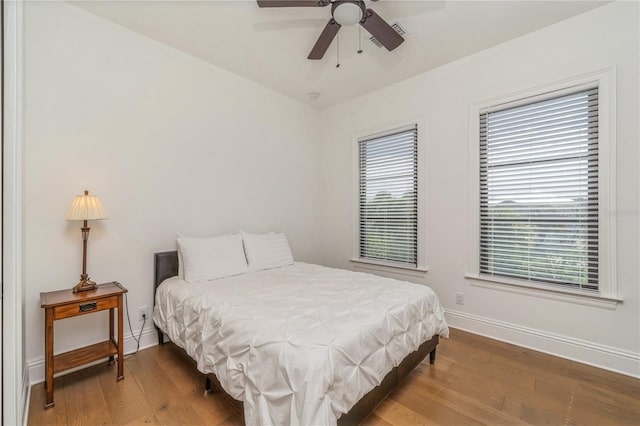 bedroom featuring hardwood / wood-style flooring, multiple windows, and ceiling fan