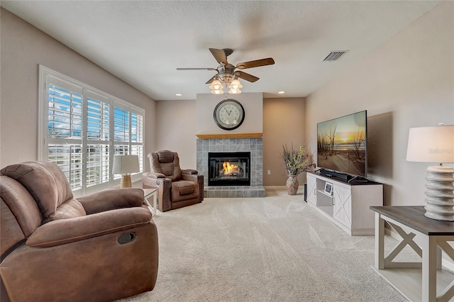 living room with light colored carpet, a fireplace, and ceiling fan