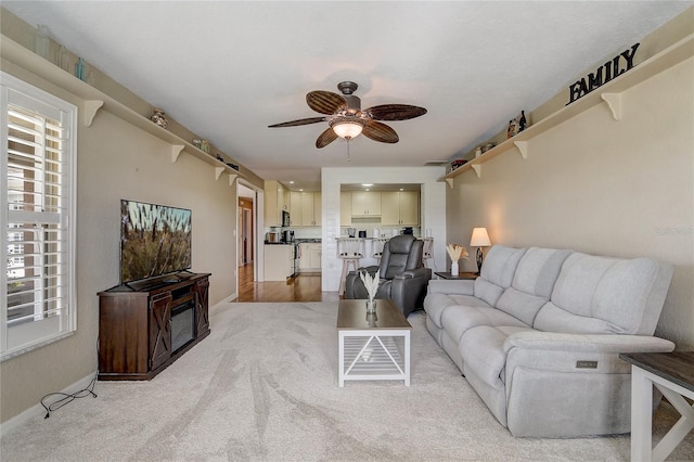 carpeted living room featuring ceiling fan