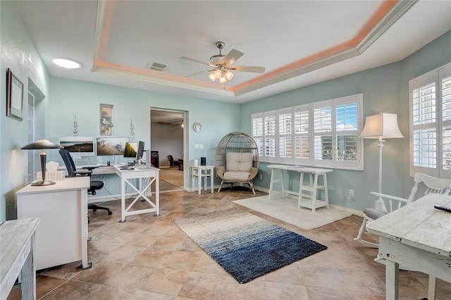 interior space featuring ceiling fan and a raised ceiling