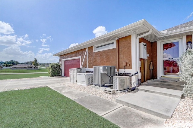 view of side of home featuring a yard, central air condition unit, and a garage