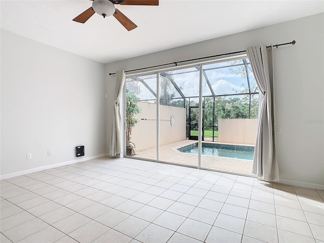 unfurnished room with light tile patterned floors, a wealth of natural light, and ceiling fan