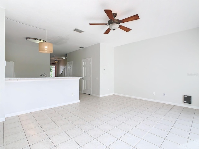 tiled spare room featuring ceiling fan