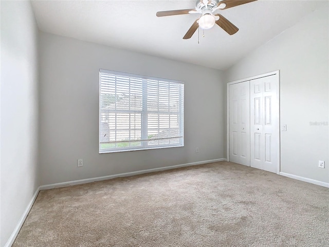 unfurnished bedroom featuring a closet, light colored carpet, ceiling fan, and lofted ceiling