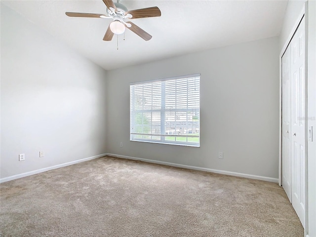 carpeted spare room featuring ceiling fan