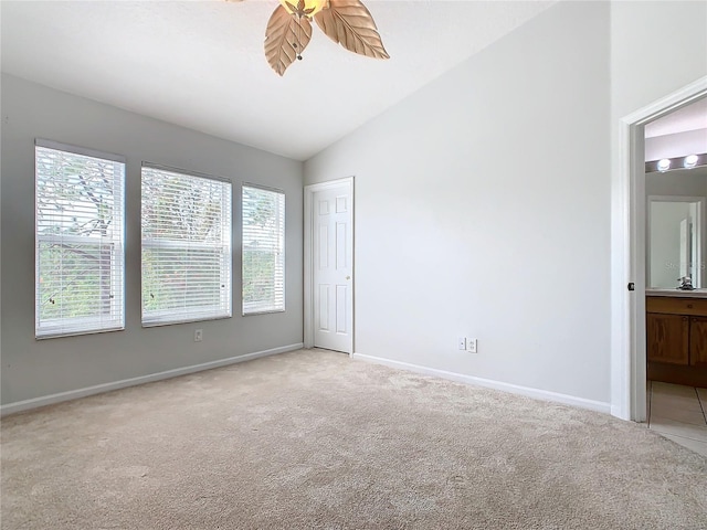 unfurnished room featuring ceiling fan, light colored carpet, and vaulted ceiling