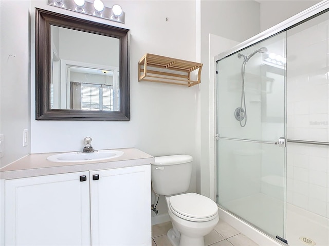 bathroom featuring tile patterned flooring, vanity, toilet, and a shower with door