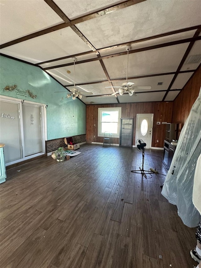 interior space featuring wood walls, ceiling fan, and dark hardwood / wood-style flooring