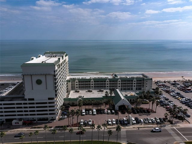 birds eye view of property with a water view and a beach view