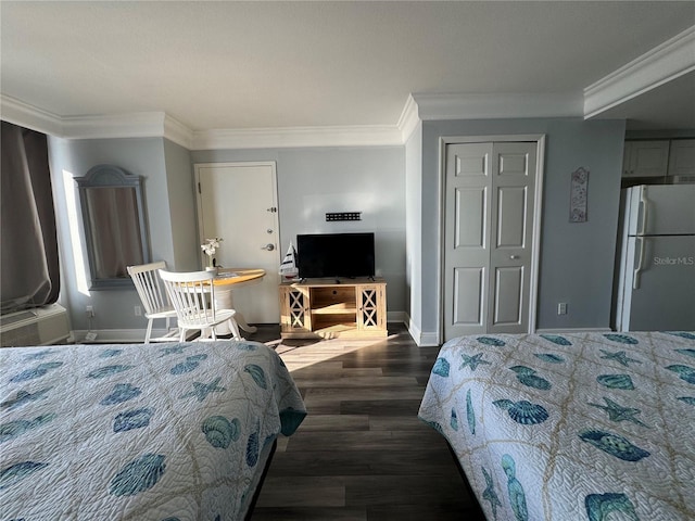 bedroom featuring dark wood-type flooring, crown molding, a closet, and white refrigerator