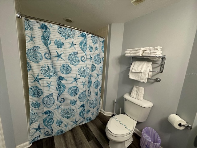 bathroom featuring a shower with shower curtain, wood-type flooring, and toilet