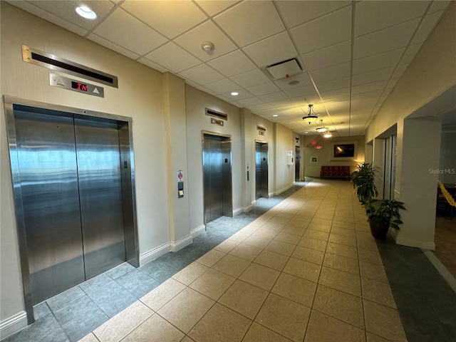 2700 N Atlantic Ave Unit 1003, Daytona Beach, FL 32118 - hallway with elevator, a paneled ceiling, tile patterned flooring, and baseboards