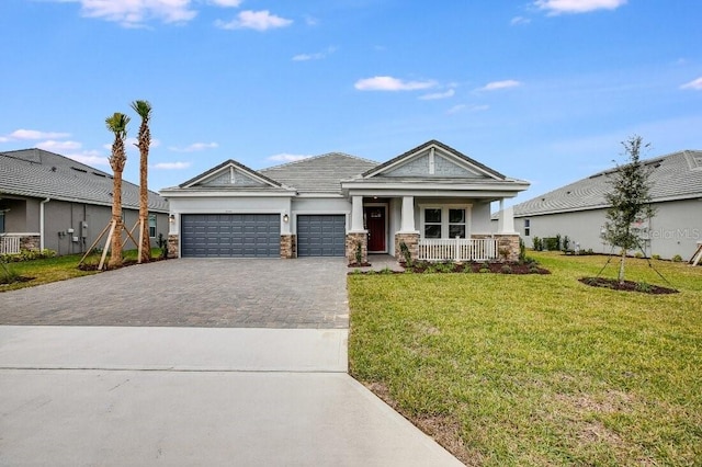 view of front of property featuring a garage, a front lawn, and covered porch