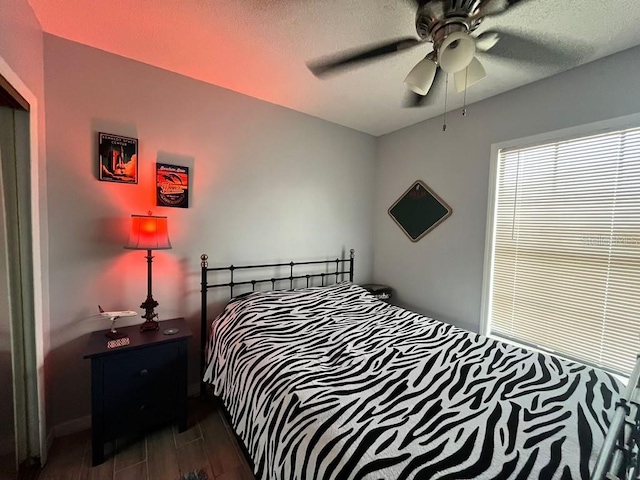 bedroom featuring a textured ceiling, dark wood-type flooring, and ceiling fan