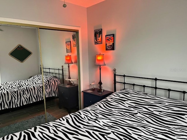 bedroom with dark wood-type flooring and a closet