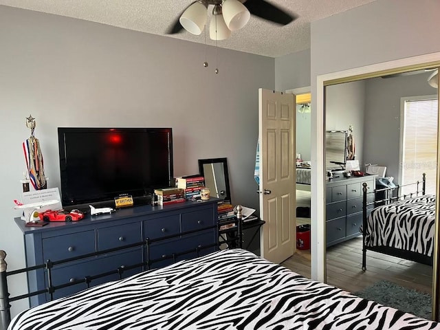 bedroom featuring ceiling fan, a textured ceiling, and hardwood / wood-style floors