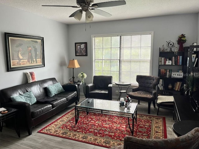 living room featuring a textured ceiling, hardwood / wood-style flooring, and ceiling fan