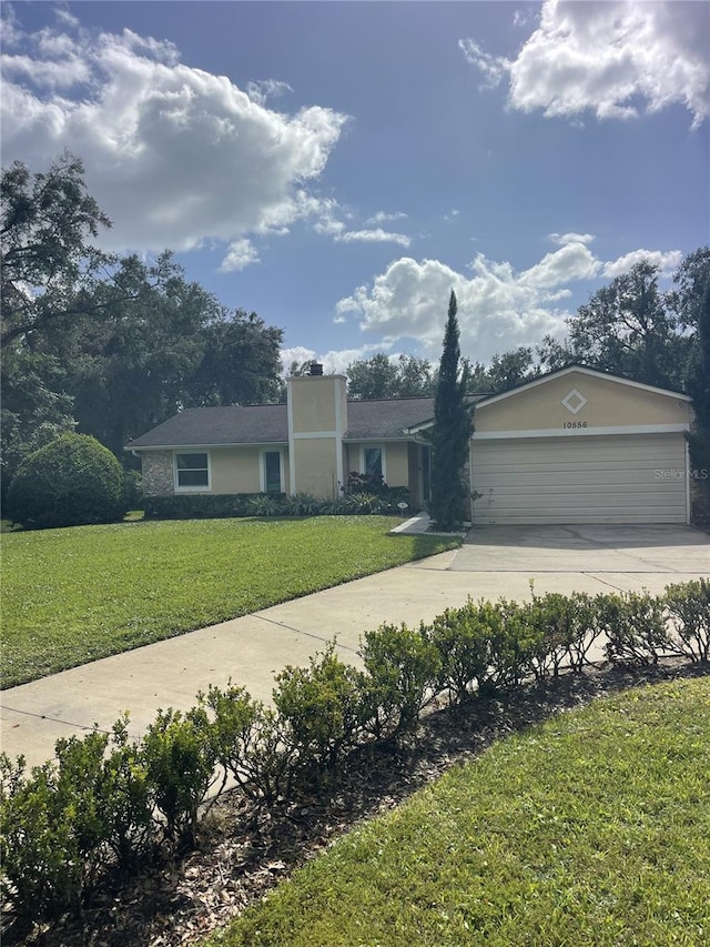 single story home featuring a front lawn and a garage