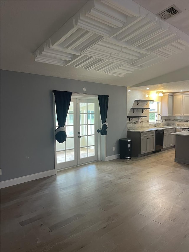 unfurnished living room with french doors, sink, and light wood-type flooring