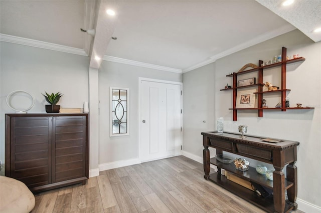 foyer entrance with ornamental molding and light hardwood / wood-style flooring