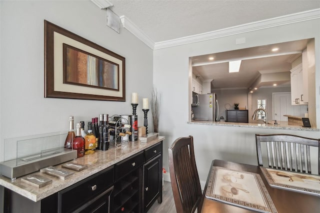 interior space with crown molding, stainless steel appliances, light hardwood / wood-style flooring, and white cabinets