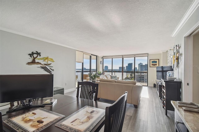 dining room with crown molding, wood-type flooring, a textured ceiling, and floor to ceiling windows