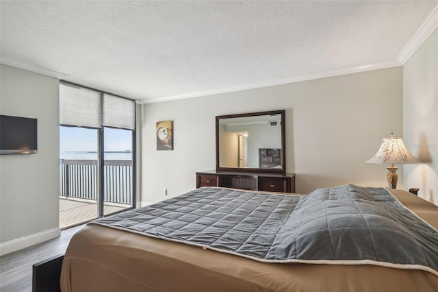 bedroom featuring hardwood / wood-style flooring, ornamental molding, a textured ceiling, and access to exterior