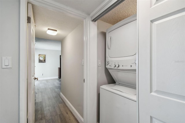 laundry area with hardwood / wood-style floors, stacked washer and dryer, and a textured ceiling