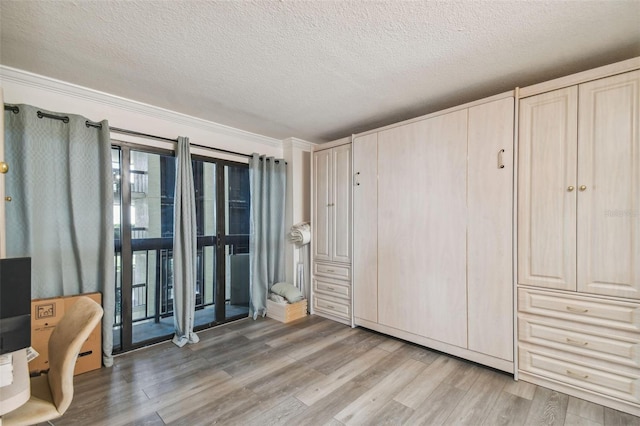 interior space with ornamental molding, a textured ceiling, hardwood / wood-style flooring, and access to outside