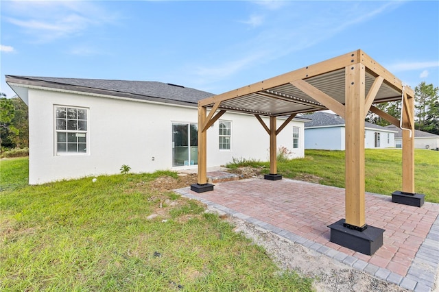 rear view of house featuring a patio, a lawn, and a pergola