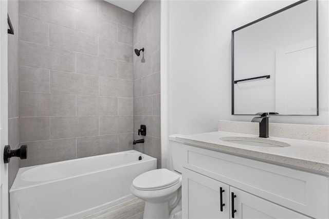 full bathroom featuring tiled shower / bath, vanity, hardwood / wood-style flooring, and toilet