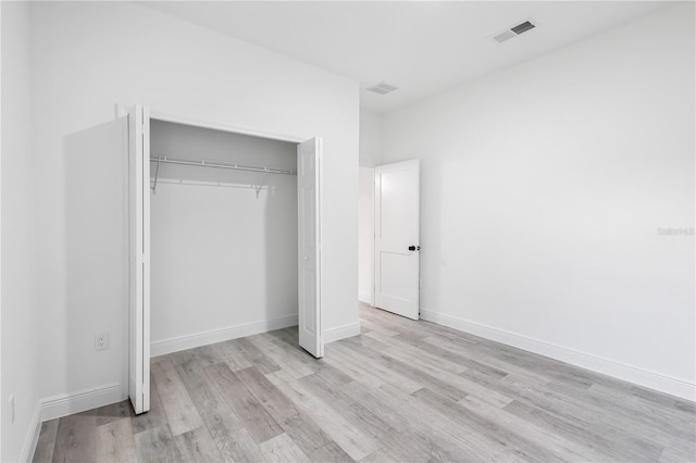 unfurnished bedroom featuring a closet and light hardwood / wood-style floors