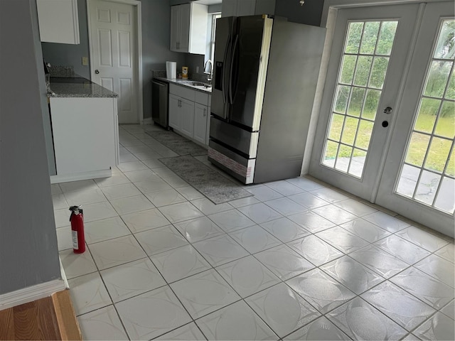 kitchen with light stone countertops, white cabinetry, french doors, black fridge, and stainless steel dishwasher