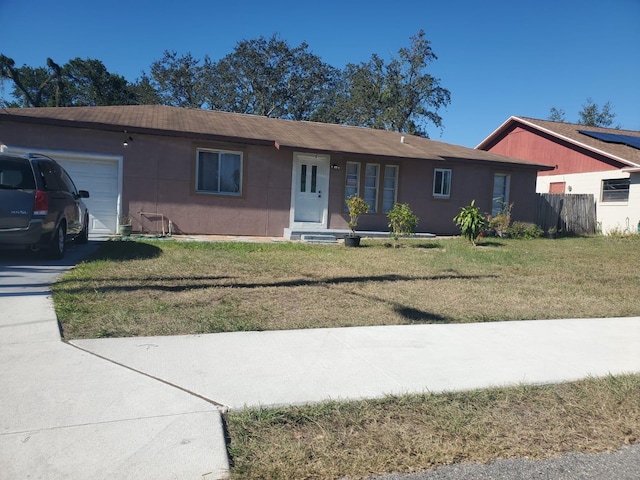 ranch-style house with a garage and a front lawn