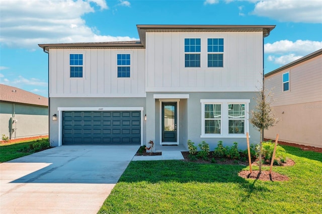 view of front of house featuring an attached garage, concrete driveway, a front yard, and board and batten siding