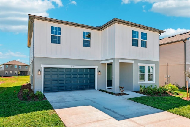 view of front of home with a garage, driveway, a front yard, and board and batten siding