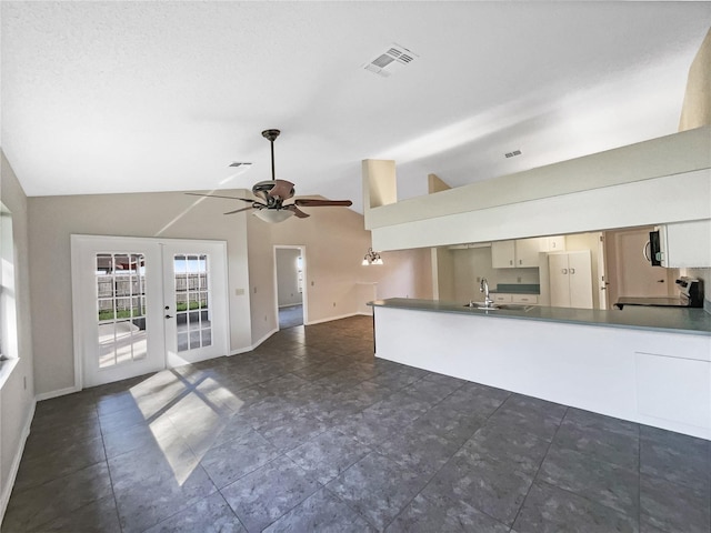 kitchen featuring french doors, high vaulted ceiling, sink, and stove