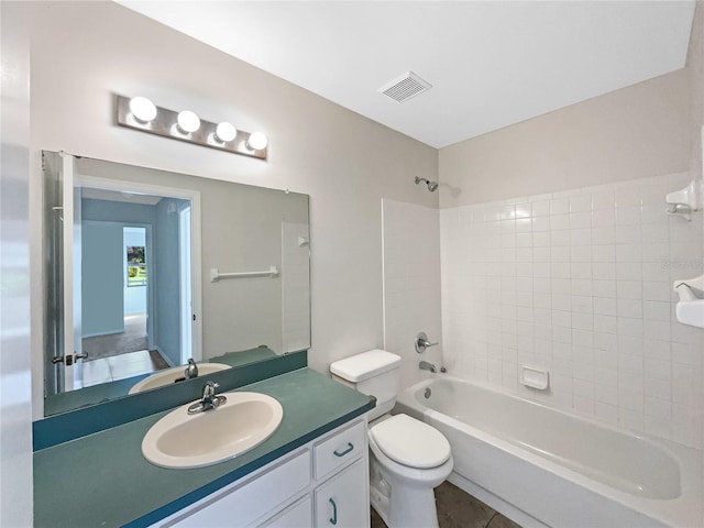 full bathroom featuring vanity, tiled shower / bath combo, toilet, and tile patterned flooring