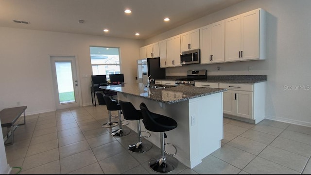 12500 Encore At Ovation Way, Winter Garden, FL 34787 - kitchen with stainless steel appliances, an island with sink, white cabinets, recessed lighting, and a kitchen breakfast bar