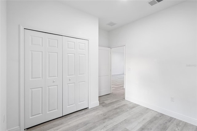 unfurnished bedroom with light hardwood / wood-style floors and a closet