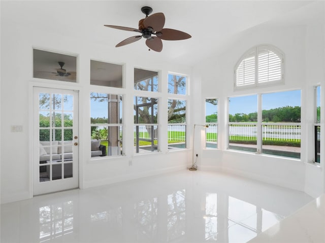 unfurnished sunroom with ceiling fan and plenty of natural light