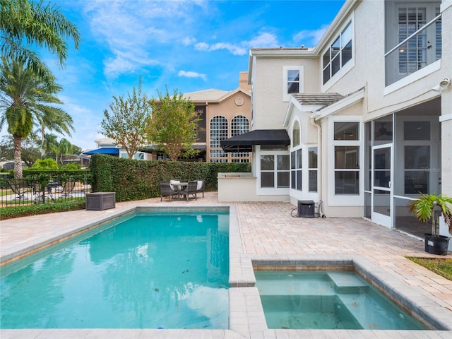 view of swimming pool featuring a patio and an in ground hot tub