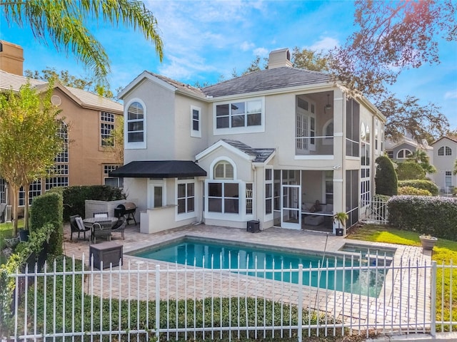 back of house featuring a fenced in pool, a patio area, and a sunroom