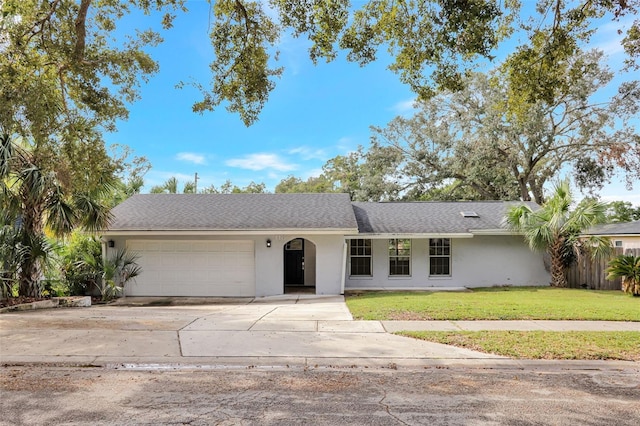 ranch-style home featuring a garage and a front lawn